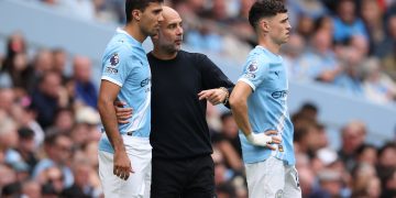 Manchester City manager Pep Guardiola speaks to Rodri of Manchester City