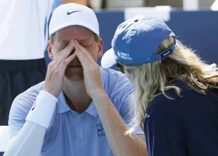 MASON (United States), 19/08/2025.- Jannik Sinner (L) of Italy talks with medical staff before retiring due to illness at 0-5 in the first set against Carlos Alcaraz of Spain during the Men's Final of the Cincinnati Open at the Lindner Family Tennis Center in Mason, Ohio, USA, 18 August 2025. (Tenis, Italia, España) EFE/EPA/MARK LYONS