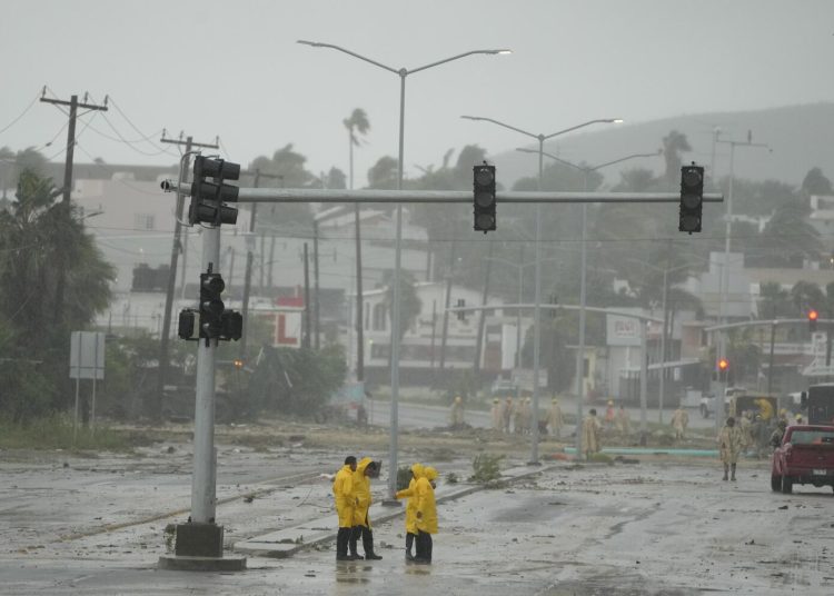 Soldados de México y un equipo de rescate remueven lodo de una avenida inundada por las lluvias causadas por el huracán Norma en San José del Cabo, México, el sábado 21 de octubre del 2023. (AP Foto/Fernando Llano)
