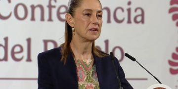 Policía y armas decomisadas, con banderas de México y Estados Unidos de fondo.