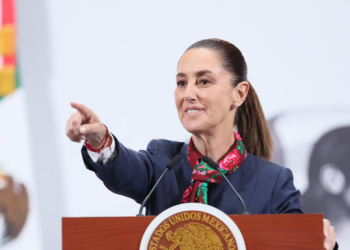 Claudia Sheinbaum, presidenta de México, alza la mano durante un evento oficial mientras se dirige a los medios de comunicación en el Palacio Nacional.