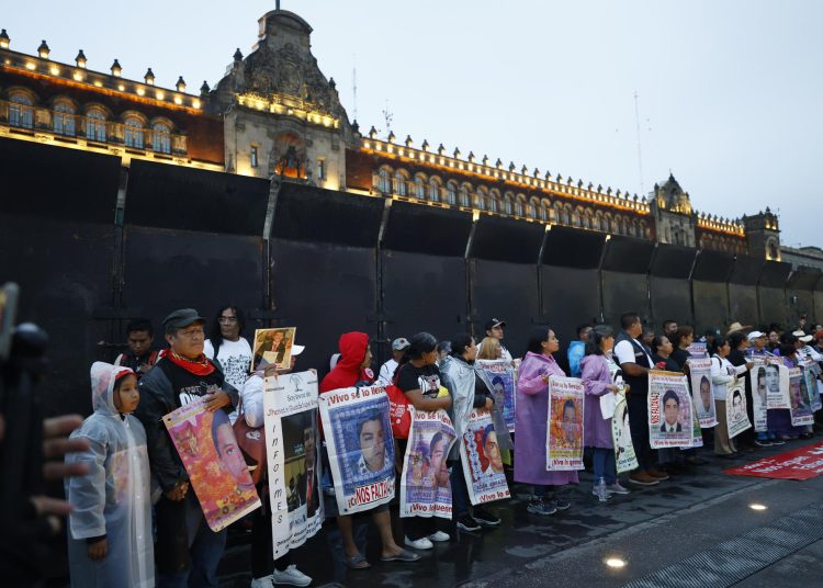 MEX3912. CIUDAD DE MÉXICO (MÉXICO), 26/09/2025.- Personas sostienen carteles en una protesta por el aniversario de la desaparición de 43 estudiantes de Ayotzinapa, este viernes en Ciudad de México (México). Tras once años de que los 43 estudiantes de la Escuela Normal de Ayotzinapa, en el estado Guerrero, desaparecieran de manera forzada por elementos del Ejército mexicano, miles de personas, entre ellos los padres de los jóvenes, salieron a las calles de la capital del país para pedir justicia sobre uno de los casos más conocidos de violaciones de derechos humanos en México. EFE/ Sáshenka Gutiérrez