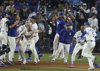 Los Angeles Dodgers Freddie Freeman (R) gets mobbed by his teammates