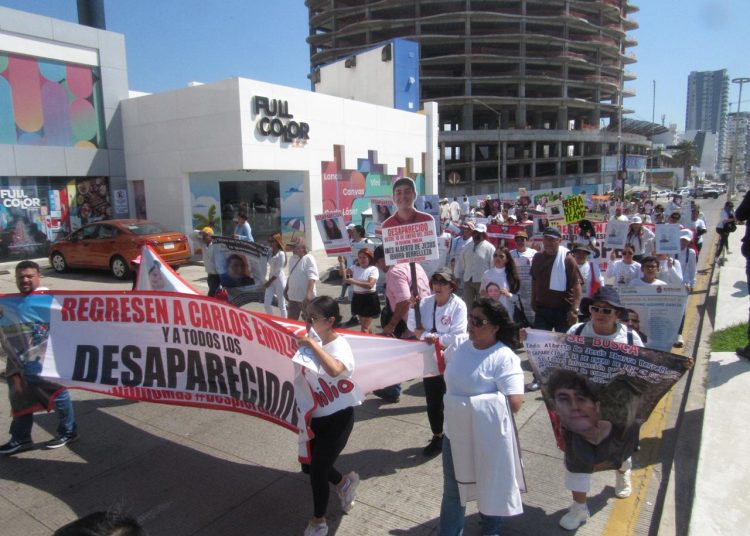 “Madres y colectivos marchan por el Malecón de Mazatlán con pancartas y fotografías para exigir justicia por jóvenes desaparecidos.”