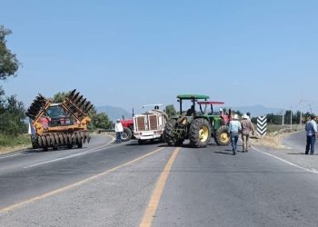 Productores de maíz retirando tractores de bloqueos carreteros en Michoacán.