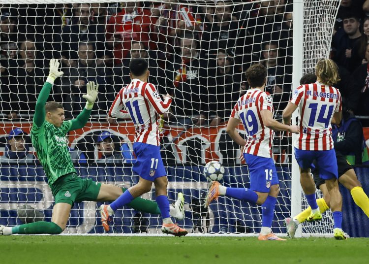 El centrocampista del Atlético de Madrid, Marcos Llorente (d), tras rematar ante el guardameta del Union Saint-Gilloise