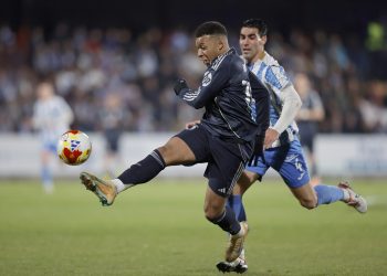 El delantero francés del Real Madrid, Kylian Mbappé, golpea el balón ante el jugador del Talavera, Álvaro López