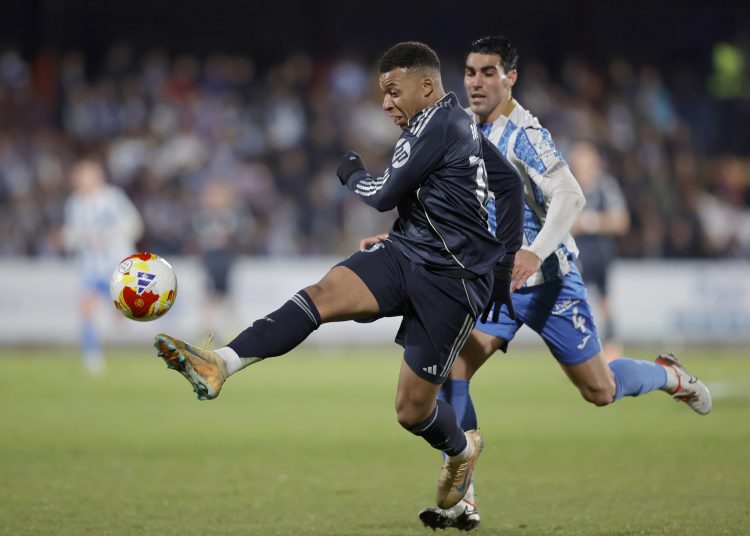 El delantero francés del Real Madrid, Kylian Mbappé, golpea el balón ante el jugador del Talavera, Álvaro López