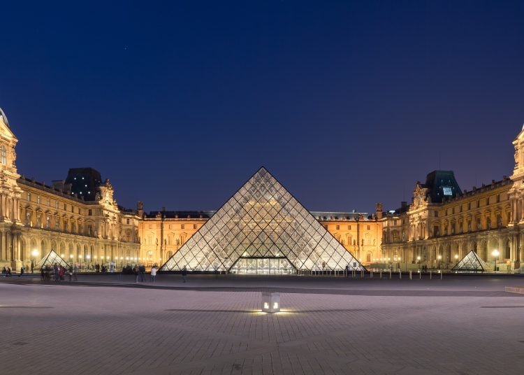 Napoleon courtyard of the Louvre museum at night time, with Ieoh Ming Pei's pyramid in the middle.