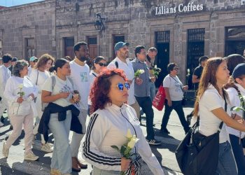 Manifestantes con rosas blancas en la fuente de Las Tarascas, Morelia, pidiendo justicia por familia de intérpretes
