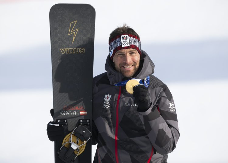 Gold medal winner Benjamin Karl of Austria poses with the medal after the snowboard parallel