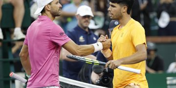 Carlos Alcaraz of Spain (R) greets Grigor Dimitrov of Bulgaria (L) at the net after Alcaraz