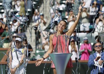 Aryna Sabalenka of Belarus poses with her Champions trophy as streamers fall after winning