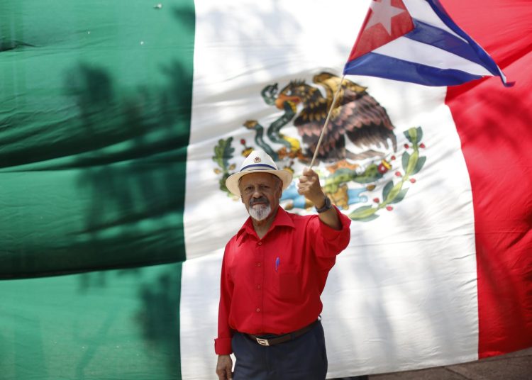 MEX7698. CIUDAD DE MÉXICO (MÉXICO), 21/03/2026.- Una persona sostiene una bandera de Cuba durante una protestan en contra del bloqueo de Estados Unidos a Cuba este sábado, en Ciudad de México (México). Con la consigna "Cuba no está sola", decenas de personas se manifestaron frente a la embajada de Estados Unidos en México para expresar su solidaridad con el pueblo cubano ante el recrudecimiento del bloqueo de EE.UU. en la isla y las amenazas de "colonización" del presidente estadounidense, Donald Trump. EFE/ Sáshenka Gutiérrez