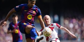 El jugador del FC Barcelona Ronald Araujo (i) lucha por el balón con Isi (d), del Rayo Vallecano