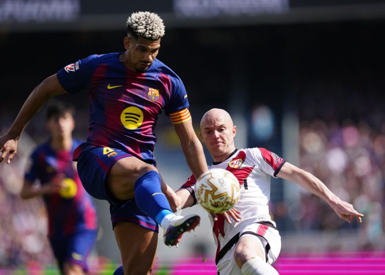 El jugador del FC Barcelona Ronald Araujo (i) lucha por el balón con Isi (d), del Rayo Vallecano