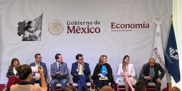 Representantes de la Secretaría de Economía y CENEVAL durante la firma del convenio