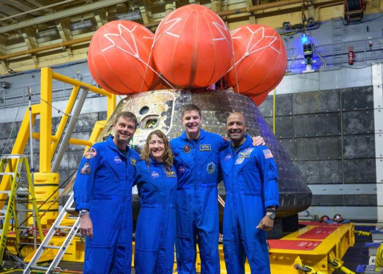Los astronautas de Artemis II posan para una foto grupal después de observar su nave espacial Orion —que ellos nombraron Integrity— en la cubierta inferior del USS John P. Murtha tras su amerizaje.