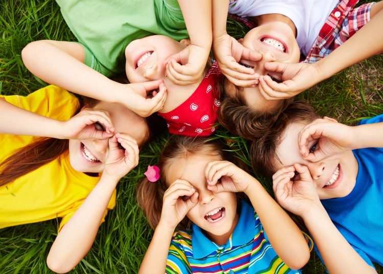 Group of cute children lying on grass