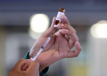 Personal médico aplicando vacunas para cortar la transmisión del sarampión entre menores y adultos