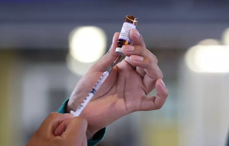 Personal médico aplicando vacunas para cortar la transmisión del sarampión entre menores y adultos