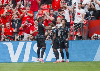 Canada forward Jonathan David (C) celebrates with teammates Cyle Larin (L) and Tajon Buchanan