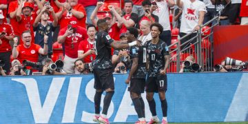 Canada forward Jonathan David (C) celebrates with teammates Cyle Larin (L) and Tajon Buchanan