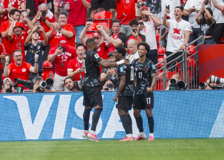 Canada forward Jonathan David (C) celebrates with teammates Cyle Larin (L) and Tajon Buchanan