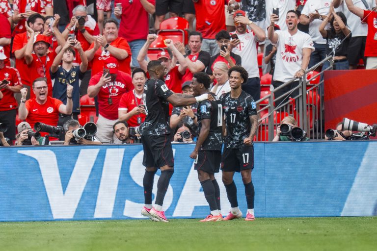 Canada forward Jonathan David (C) celebrates with teammates Cyle Larin (L) and Tajon Buchanan
