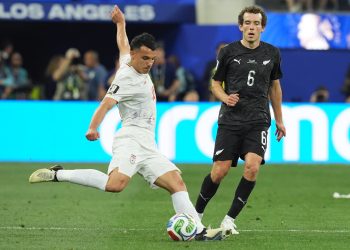 Amirhossein Hosseinzadeh (i) de Irán disputa un balón con Joe Bell de Nueva Zelanda