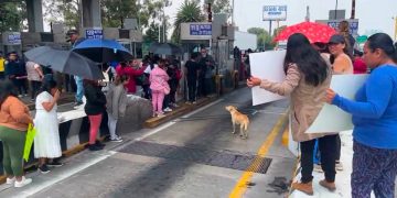 Maestros y padres de familia se manifiestan en la caseta México - Puebla