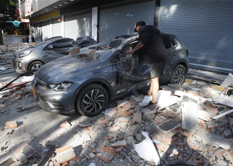 AME7612. CALI (COLOMBIA), 10/08/2026.- Un hombre observa un vehículo afectado tras un fuerte temblor este lunes, en Cali (Colombia). Un temblor de magnitud 7,4 sacudió gran parte de Colombia, según el Servicio Geológico Colombiano (SGC), y las autoridades informaron de daños en varias ciudades como Manizales, Cali y Pereira. EFE/ Ernesto Guzmán